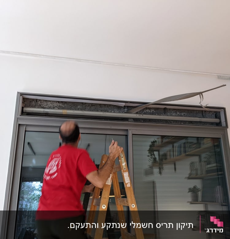 אדם על סולם מתקן תריסים שבורים
